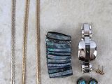 plusieurs bijoux, dont une montre, un bracelet et des boucles d'oreilles