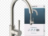 a close up of a kitchen faucet with a box in the background
