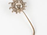 une broche en forme de fleur en argent ornée d'une coccinelle