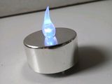 a small silver candle with a blue flame on it