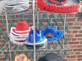 many hats that are sitting on a rack