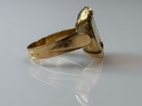 a gold ring with a stone in it on a white surface