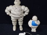une figurine représentant un homme avec une chaîne autour du cou et une petite figurine représentant un homme avec une chaîne autour du cou