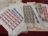 a lot of old stamps on a table with a pair of scissors