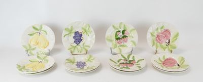 quatre assiettes ornées de fleurs peintes sont alignées sur une surface blanche