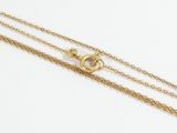 a close up of a gold chain with a heart on it