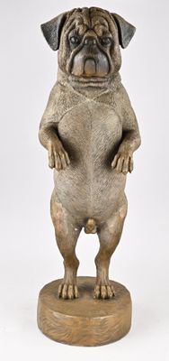 statue d'un carlin debout sur ses pattes arrière, posée sur un socle en bois