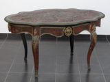 une petite table avec un plateau en marbre posée sur un sol carrelé