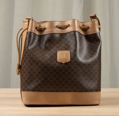 a brown and tan purse sitting on top of a wooden table