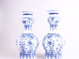 une paire de vases bleus et blancs posés sur une table blanche