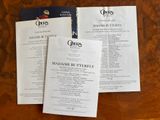 three menus sitting on a table with a menu in front of them