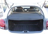 the back of a white car with its trunk open in a parking lot