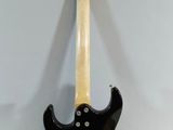a black electric guitar sitting on top of a white wall
