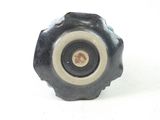 a black knob with a white center on a white surface
