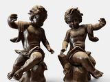two statues of children sitting on top of a tree stump