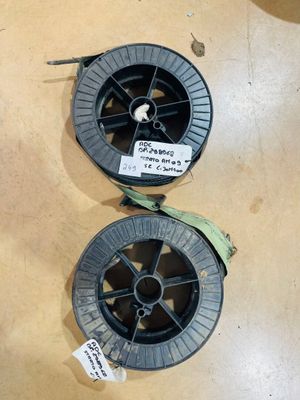 two spools of black plastic are sitting on a table