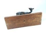 a statue of a whale sitting on a wooden block
