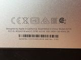 the back of a silver laptop with a barcode on it