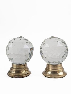 a pair of clear glass door knobs on gold bases