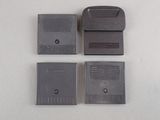three nintendo game cartridges sitting next to each other on a white surface