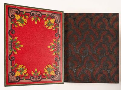un livre ouvert à couverture rouge posé sur une table blanche