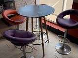 three chairs and a table in a room with a large window