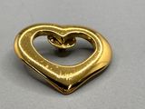 une broche en or en forme de cœur posée sur une table
