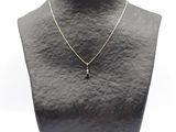 un collier noir et blanc orné d'une croix, porté par un mannequin