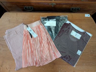 three pairs of skirts are on a table next to a chest of drawers