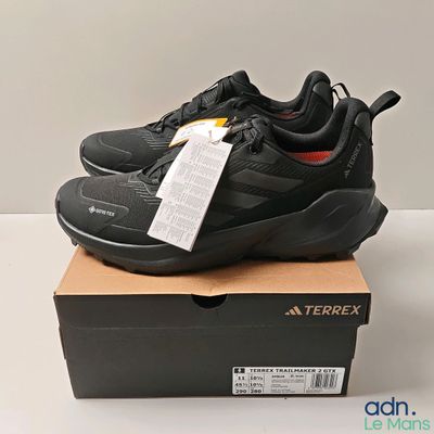 the black sneakers are on a box with a price tag