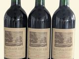 trois bouteilles de vin posées sur une table l'une à côté de l'autre