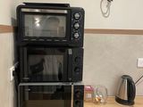 deux micro-ondes et un four grille-pain sur le plan de travail de la cuisine