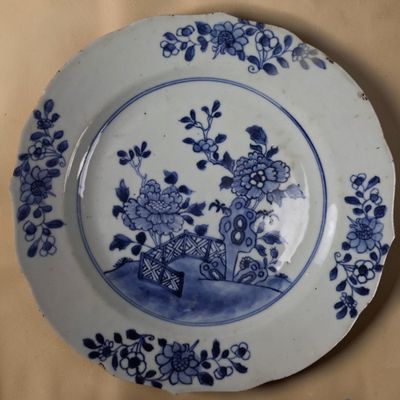 une assiette bleue et blanche décorée de fleurs, posée sur une table