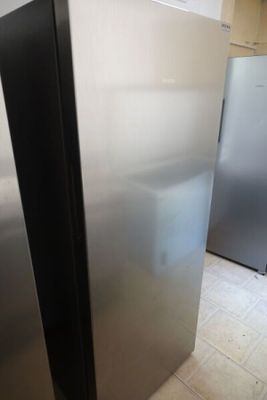 a silver refrigerator in a kitchen with a white tile floor
