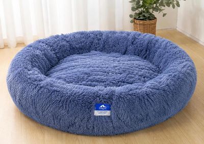 a blue dog bed sitting on top of a wooden floor