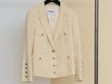 the jacket is hanging on a hanger in front of a wall