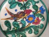 a plate with a bird and flowers on it