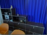 une photo d'une pièce avec un rideau bleu et un bureau