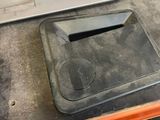 a laptop computer sitting on top of a trash can next to a tire