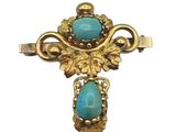 une image représentant une croix en or sertie d'une pierre turquoise