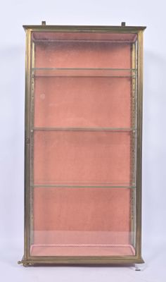an antique brass bookcase with glass shelves on a white background