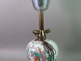 a vase with a bell on top of it on a table