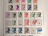 un livre ouvert sur lequel sont collés plusieurs timbres de différentes couleurs