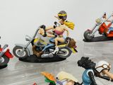many figurines of people riding motorcycles in a display case