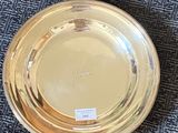 a gold plate sitting on a blue carpet next to a rug