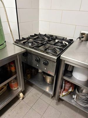 a kitchen with a stove, sink, and cabinets in it