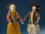two figurines of a man and a woman dressed in costumes