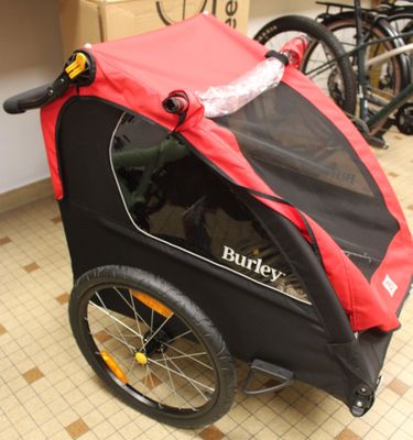a red and black stroller with a red cover on it
