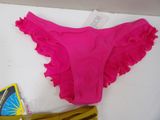 a pink bikini with ruffles on it next to a pair of shoes