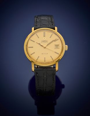 a gold plated wrist watch with a black leather strap